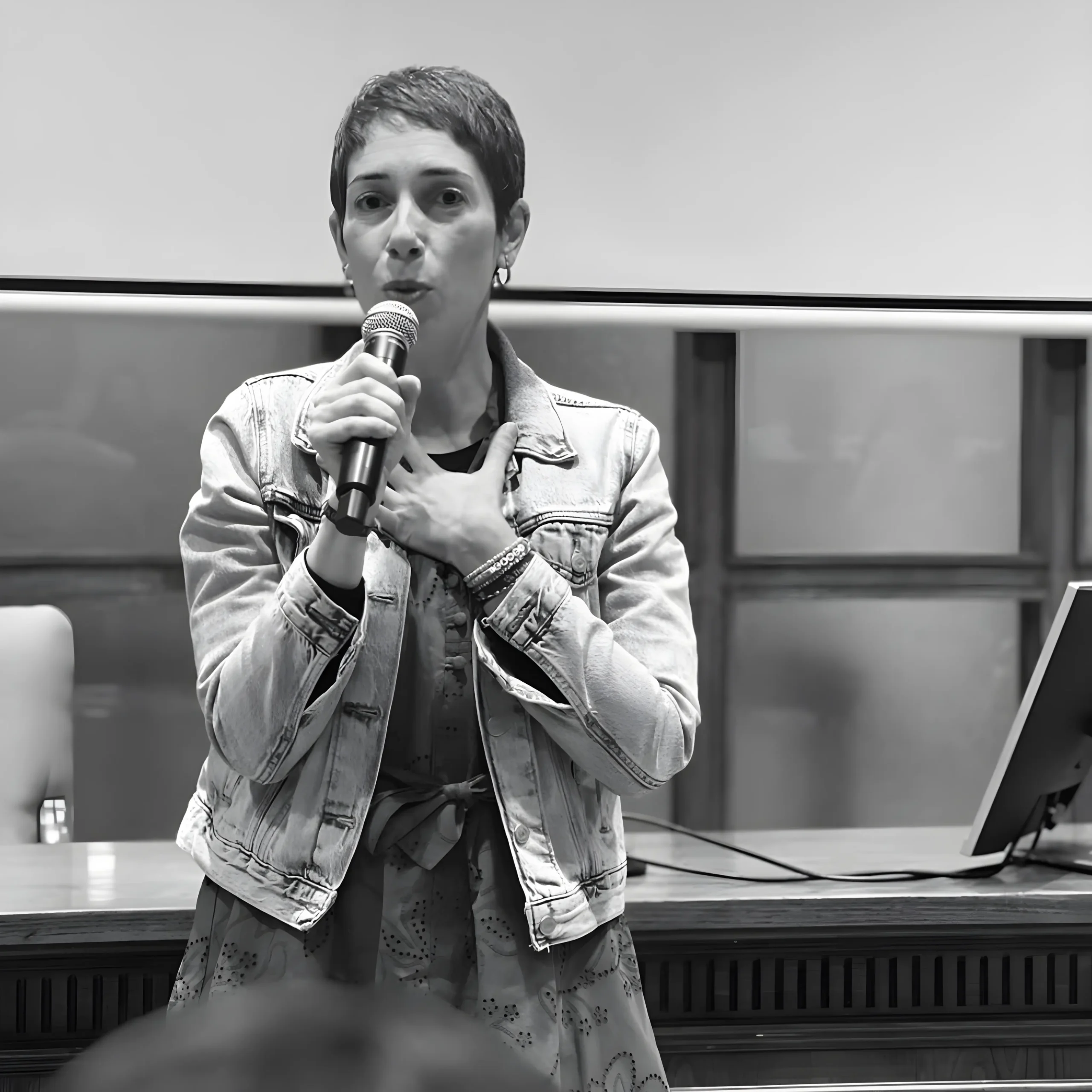 Analista de comunicación no verbal y detección de mentira Persona hablando con micrófono en conferencia.