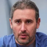 Persona con camiseta azul mira al frente